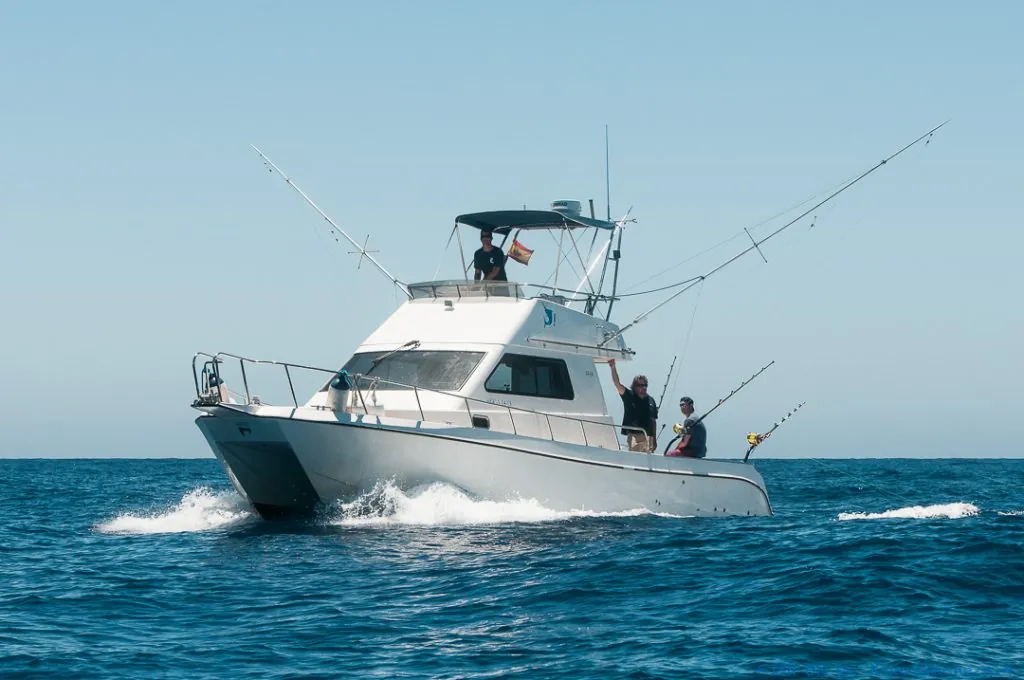 Fish On! sportfisher running at speed with the outriggers out